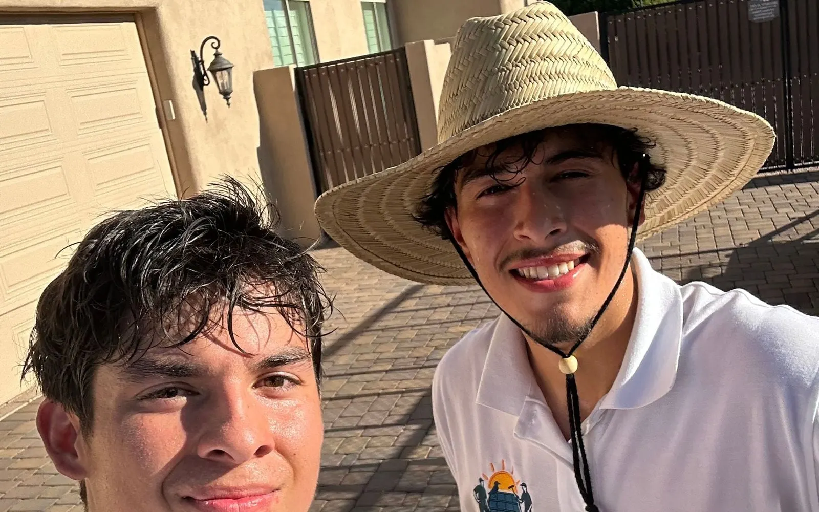 Two smiling SunGuys crew members in uniform shirts and a sun hat after a job
