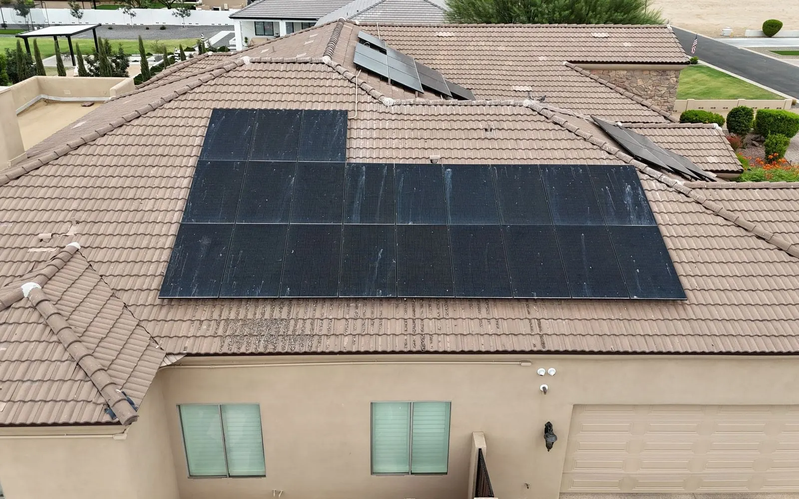 Drone view of freshly cleaned solar panels on a tan tile roof